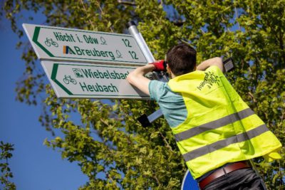 Mitarbeiter von VAR+ montiert Radwegweiung Ein Mitarbeiter des Büros VAR+ montiert Radwegweisung